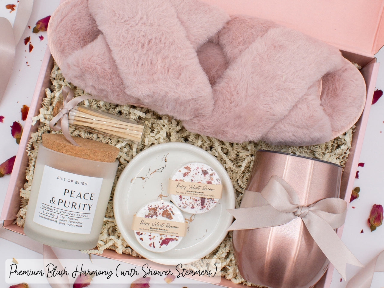 Luxury gift box for her. Featuring a stainless steel tumbler, an aromatherapy candle with matches, aromatic shower steamers, sleek ceramic dish, and plush open-toe slippers. All items are beautifully arranged for a pampering experience.