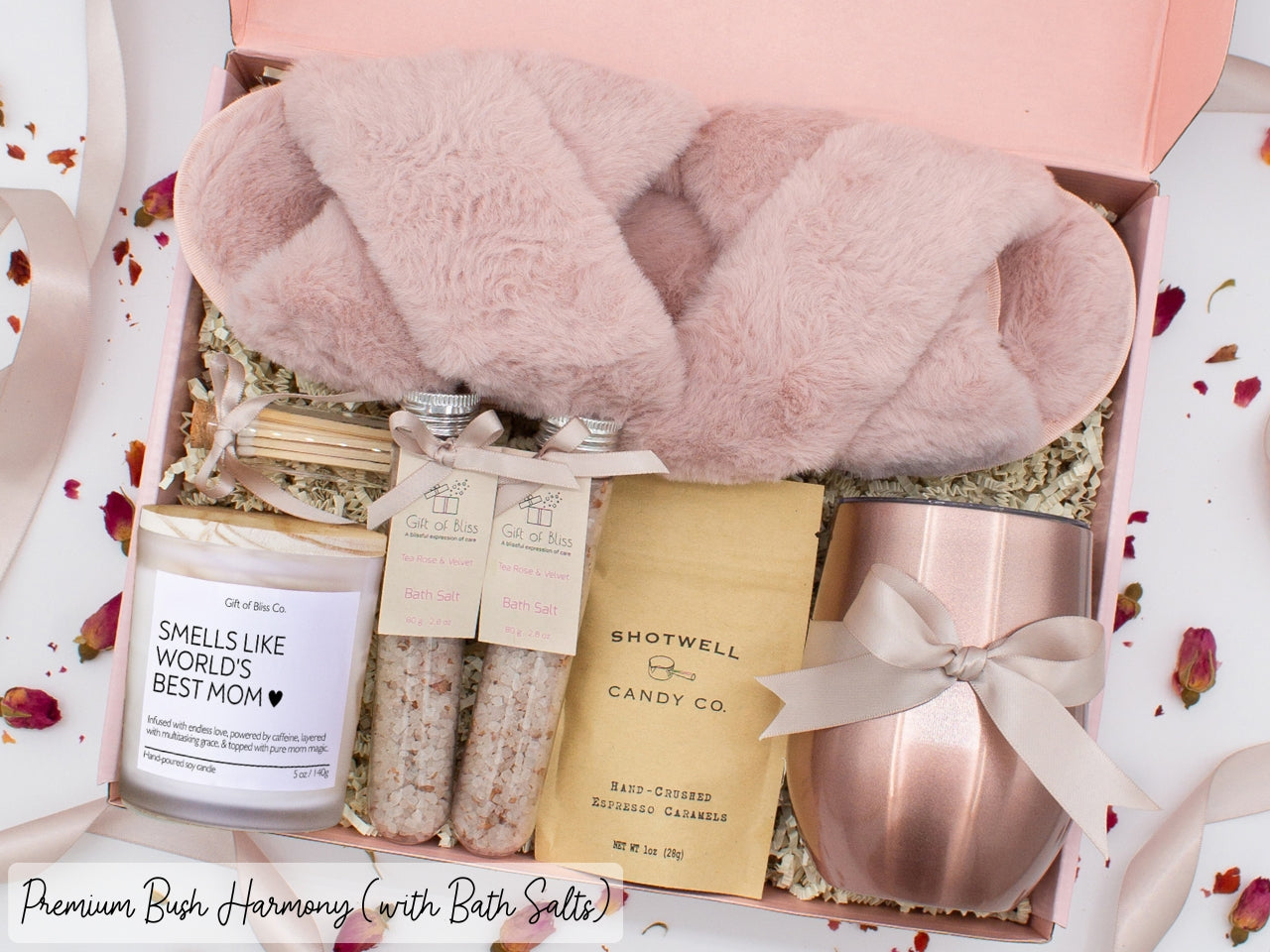 Luxury gift box for her. Featuring a stainless steel tumbler, an aromatherapy candle with mom-themed label and a charming match jar, therapeutic bath salts, plush open-toe slippers, and gourmet caramel treats. All items are beautifully arranged for a pampering experience.