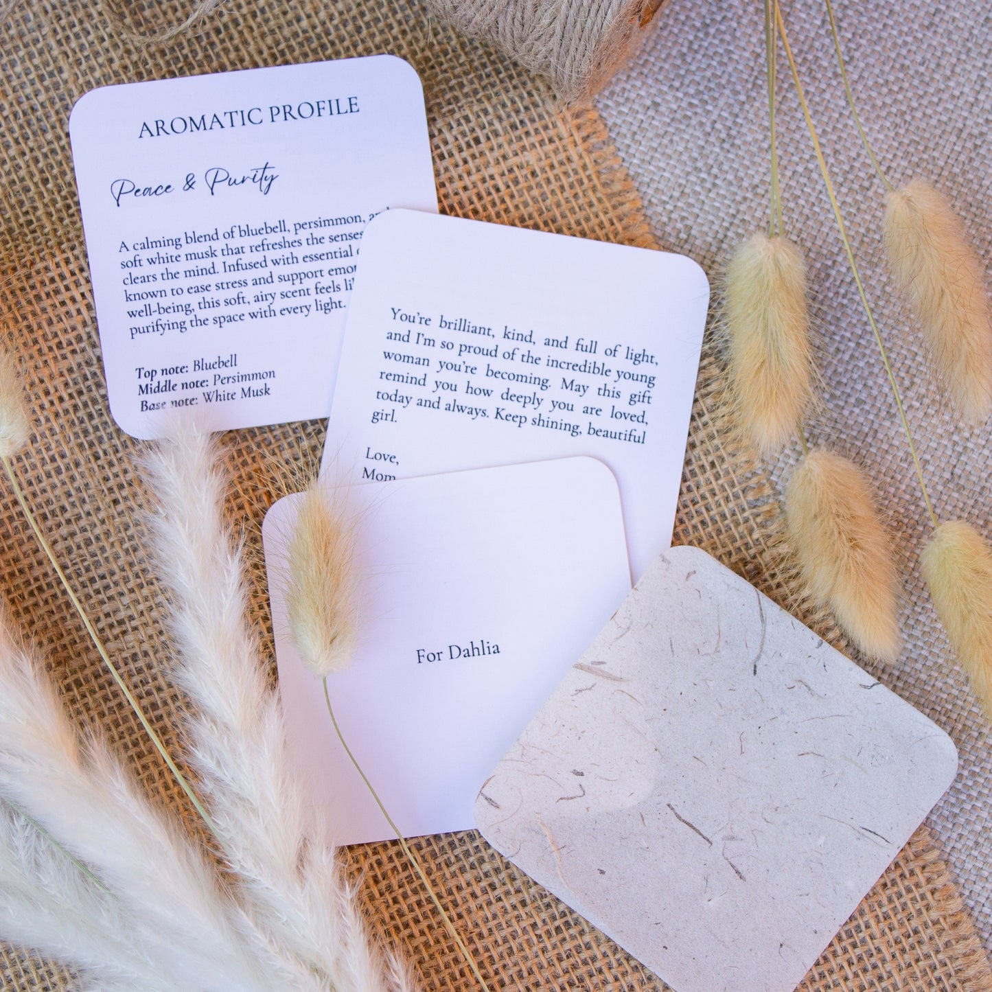 Candle gift box featuring a “Smells Like the World’s Best Mother” soy candle, glass match jar, and a rustic-style personalized message booklet tied with jute twine. Arranged in a kraft box with crinkle paper filler and neutral tones, this cozy, handcrafted gift is perfect for Mother’s Day or mom appreciation. A heartfelt and aesthetic set that combines warmth, functionality, and rustic charm.
