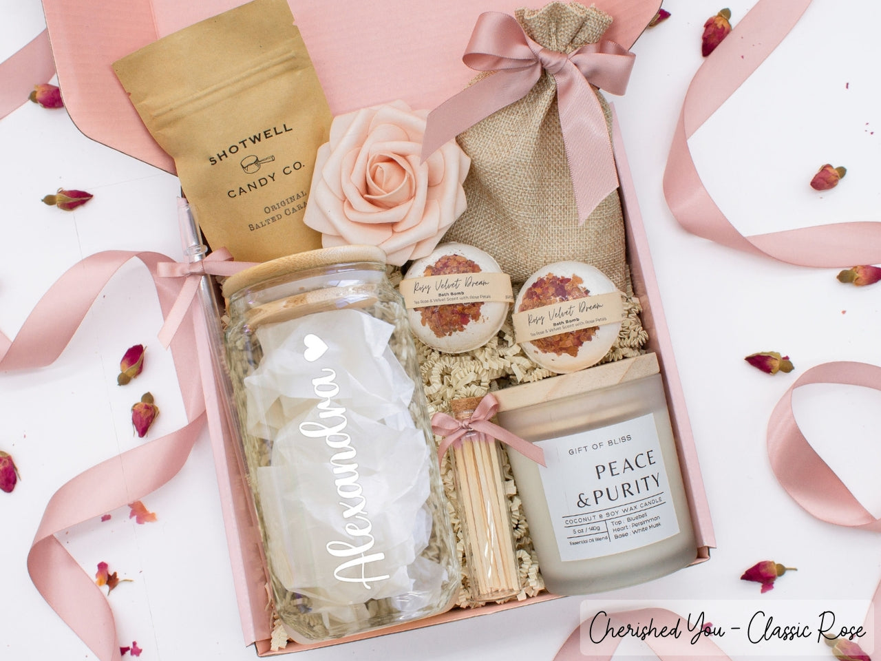 Pesonalized spa gift basket for her with fragrant bath treats, personalized glass tumbler, soft caramels, relaxing candle, and a beautifull rose. Pick from one of the three scents: Rose, Lavender, or Jasmine. Perfect to pamper and honor her.