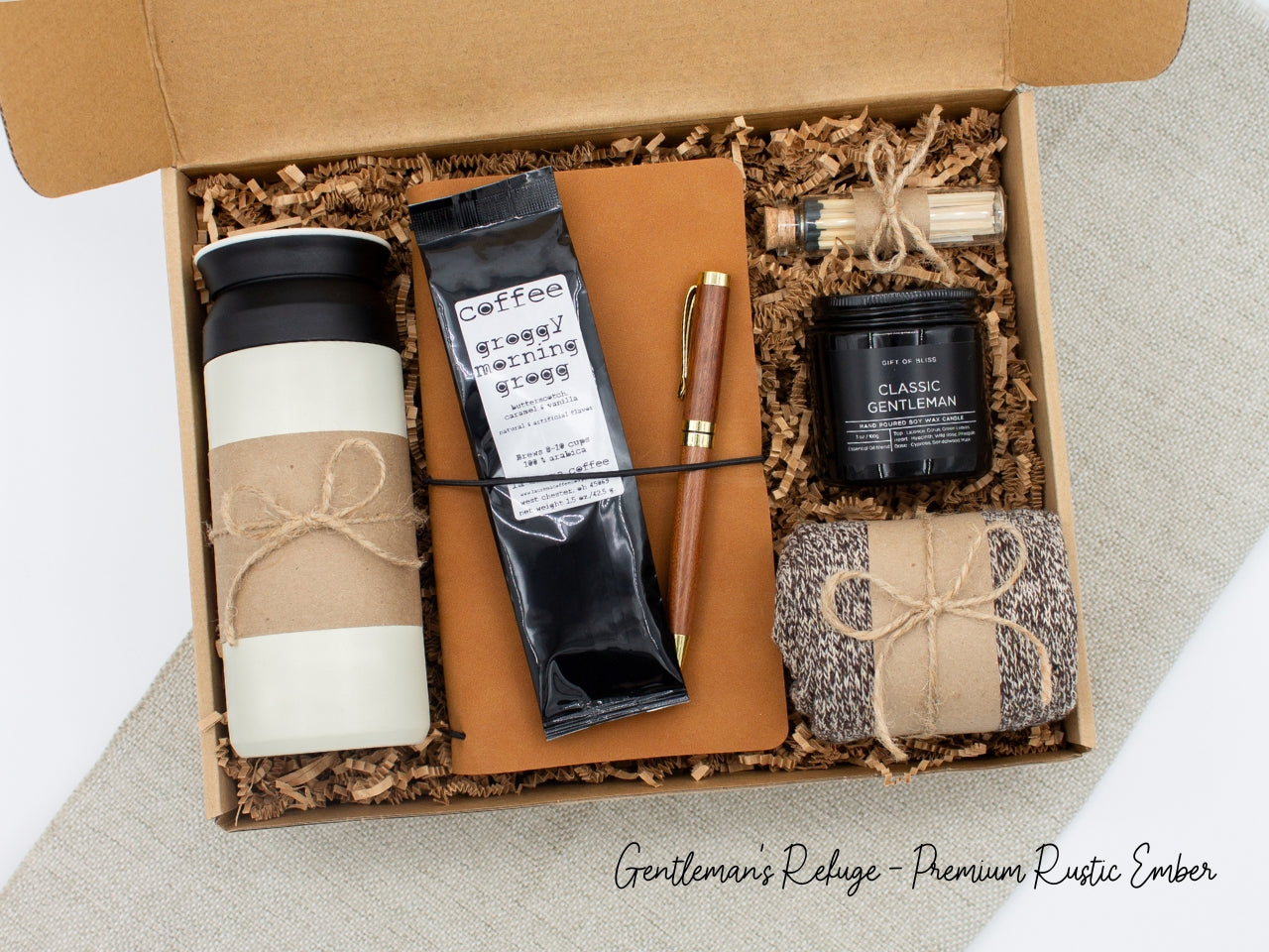 Specially crafted gift box for men, suitable for anyone valuing timeless style. Includes a stainless steel tumbler, coffee, aromatherapy candle, men's socks, notebook, and a wooden pen. A perfect gift for a comforting & indulgent experience.
