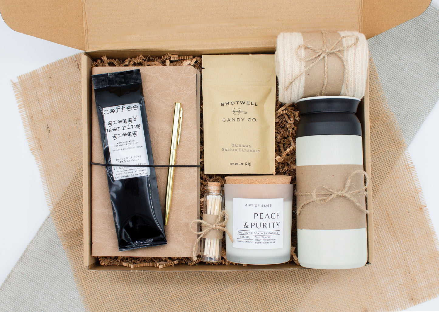 A specially crafted gift box for those who appreciate rustic charm and elegance. Features 12 oz tumbler, coffee, luxurious caramel, notebook with gold pen, soothing candle with matches, and cozy socks, perfect for both relaxation and practicality.