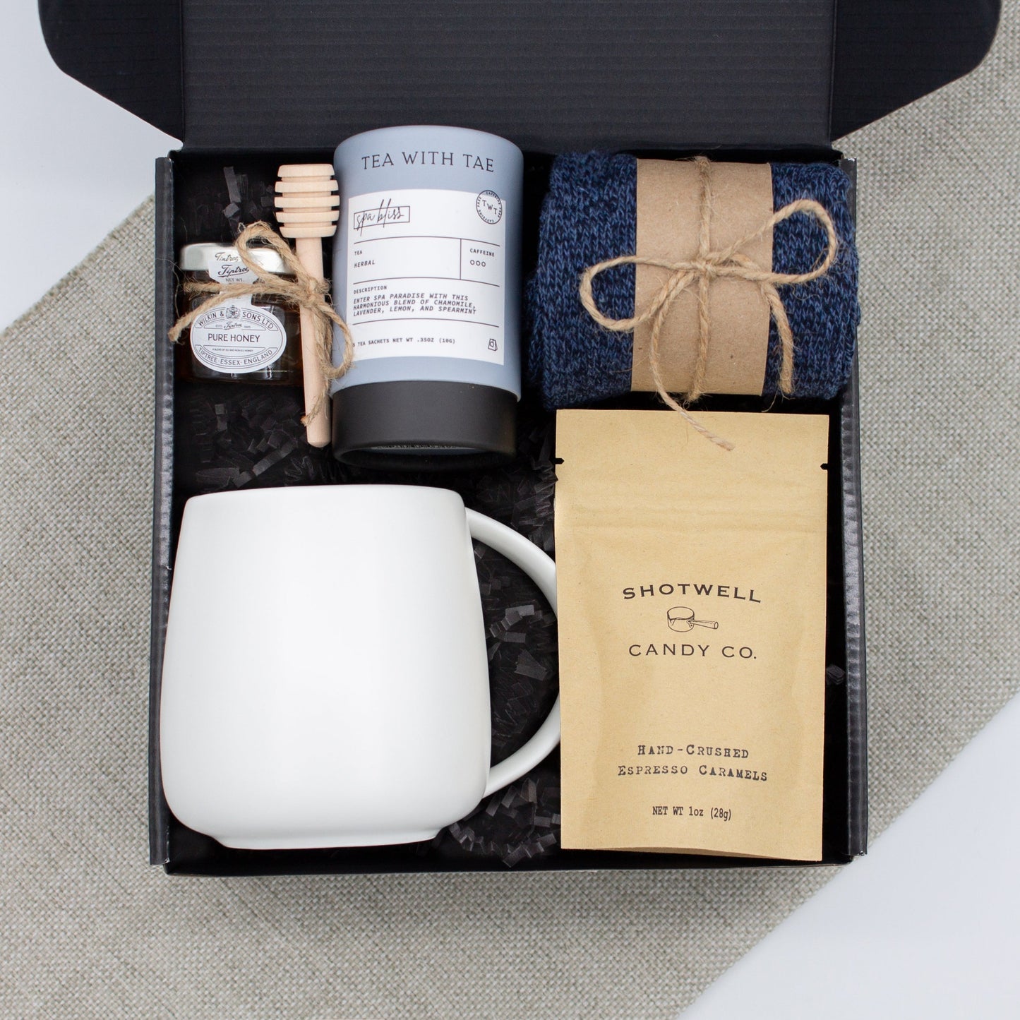 The Dapper Haven Basic (Specially crafted gift box for men. Includes a minimalist ceramic mug, tea, pure honey with wooden dipper, caramel candy, and cozy men's socks. A gift that brings joy and a touch of tranquility to anyone who loves life's finer things.)