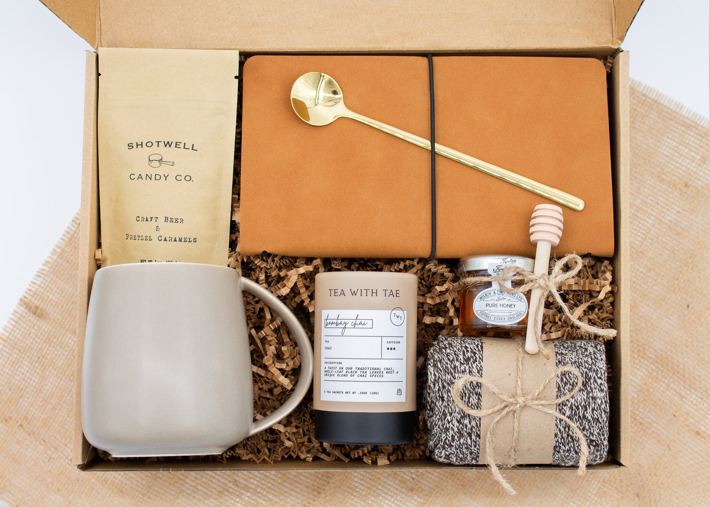 The Dapper Haven (Specially crafted gift box for men. Includes a ceramic mug, golden spoon, tea, honey with dipper, caramel candy, men's socks, and a vegan leather notebook. A gift that brings joy and a touch of tranquility to anyone who loves life's finer things.)