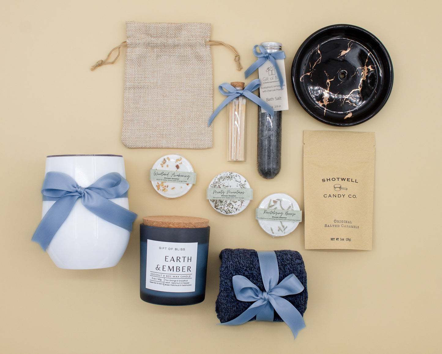 Specially crafted gift box that brings luxury and relaxation. Includes a 12oz stainless steel tumbler, sweet treats, an aromatic candle and matches, cozy socks, bath salt, shower steamers, and an elegant ceramic dish for a serene experience.