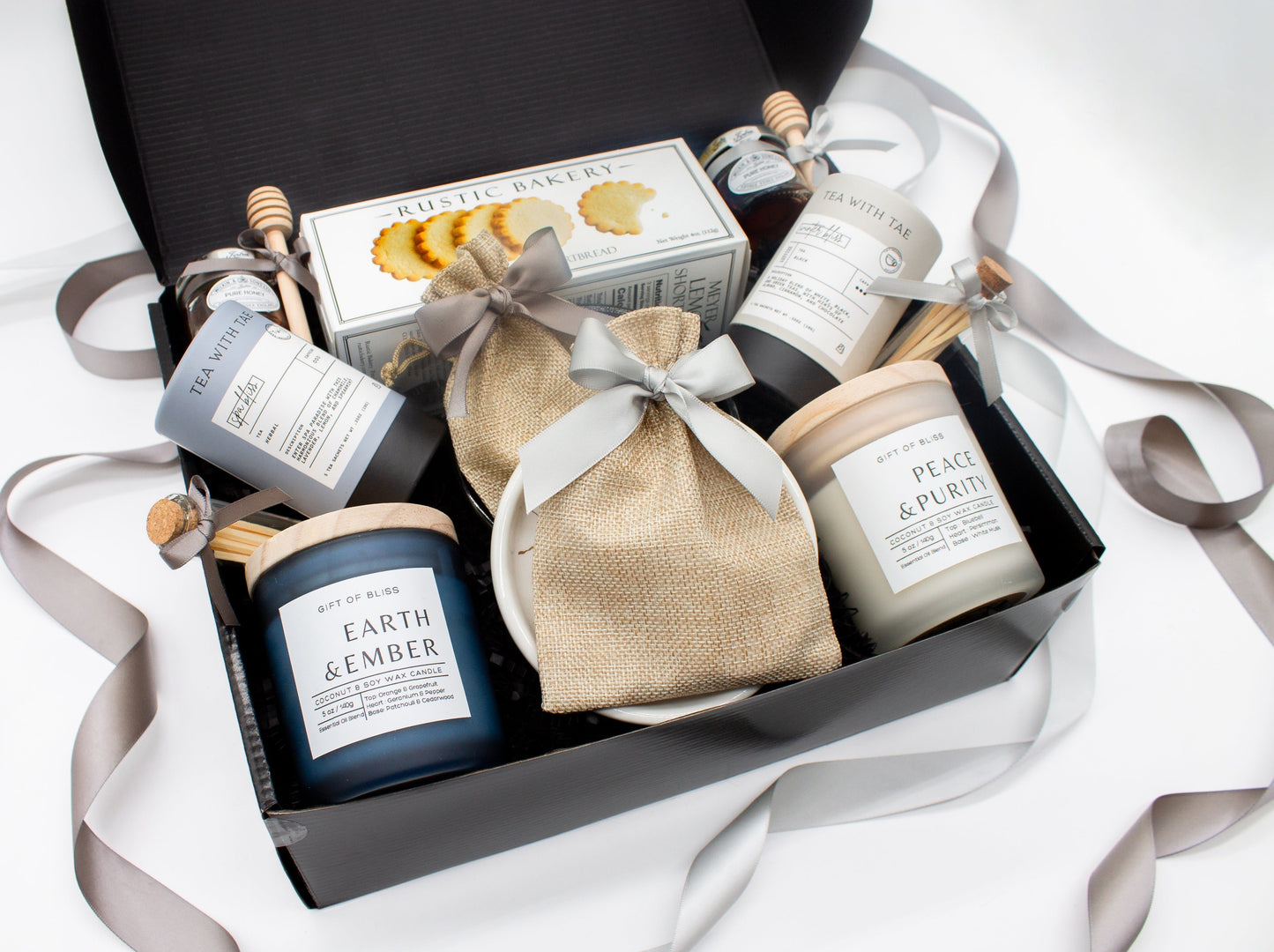 A spa gift box for 2. Features shortbread cookies, 2 soothing tea blends, honey and wooden dipper, 2 aromatic candles, and 2 sets of shower steamers. This elegantly curated box, ideal for couples, enhances shared moments of intimacy and relaxation.