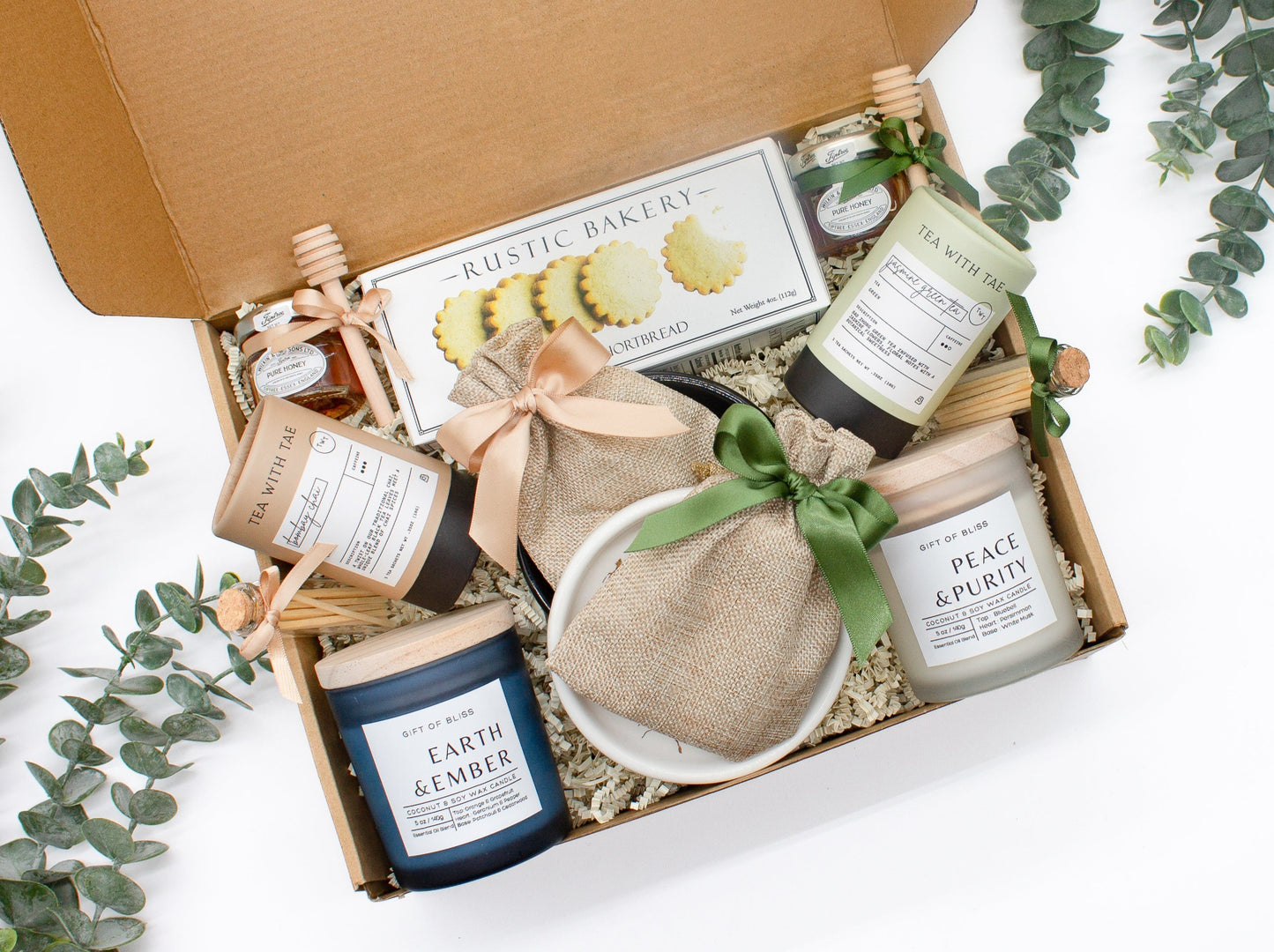 A spa gift box for 2. Features shortbread cookies, 2 soothing tea blends, honey and wooden dipper, 2 aromatic candles, and 2 sets of shower steamers. This elegantly curated box, ideal for couples, enhances shared moments of intimacy and relaxation.