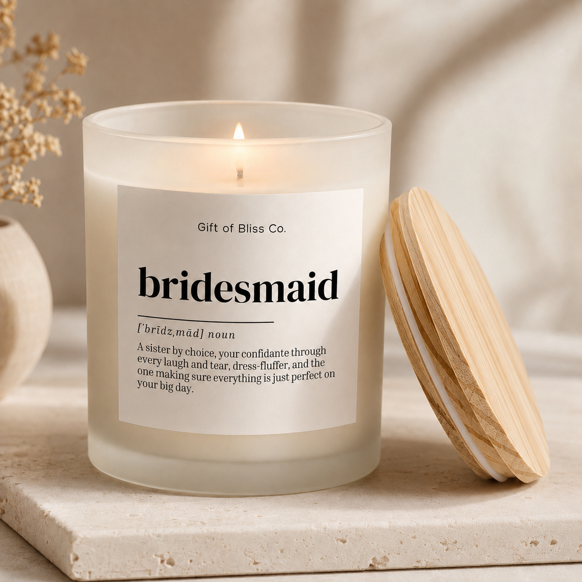 Lit bridesmaid definition soy candle in a 5 oz frosted jar with its wooden lid resting beside it