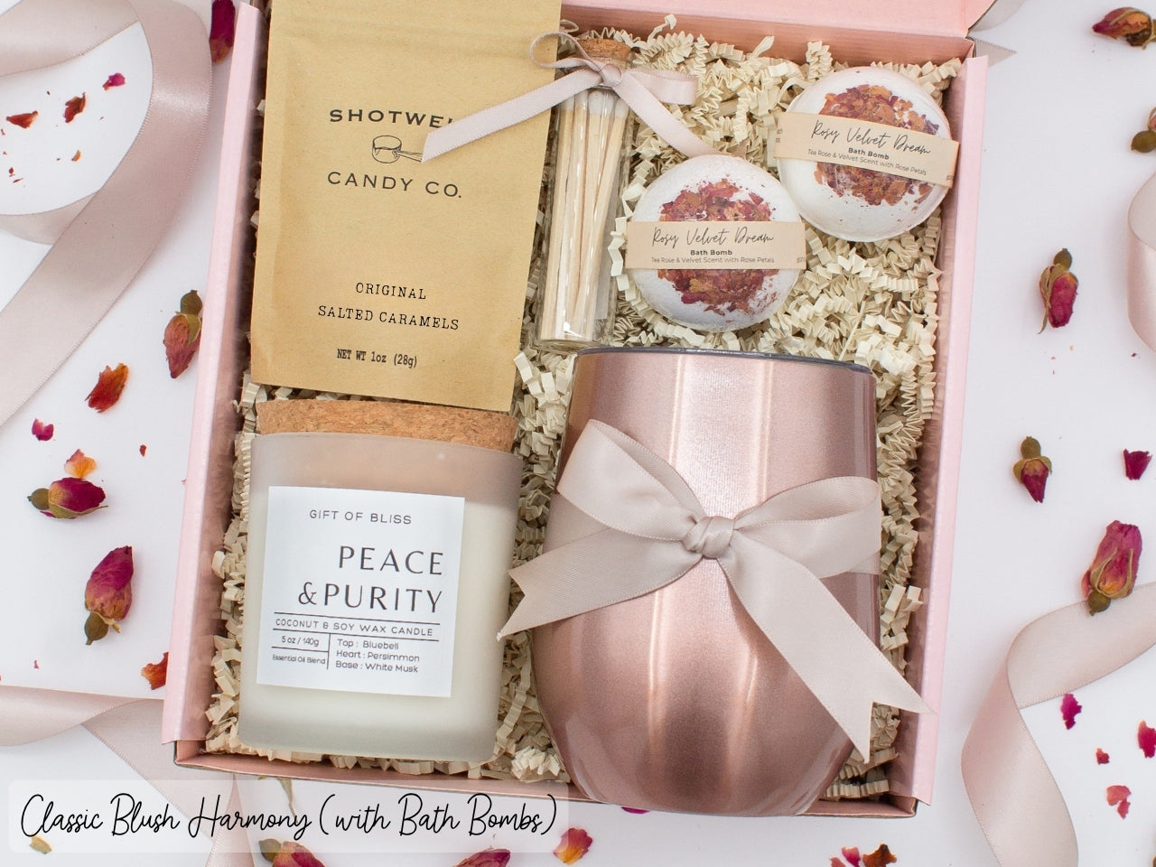 Luxury gift box for her. Featuring a stainless steel tumbler, an aromatherapy candle with matches, luxury bath bombs, and gourmet caramel treats. All items are beautifully arranged for a pampering experience.