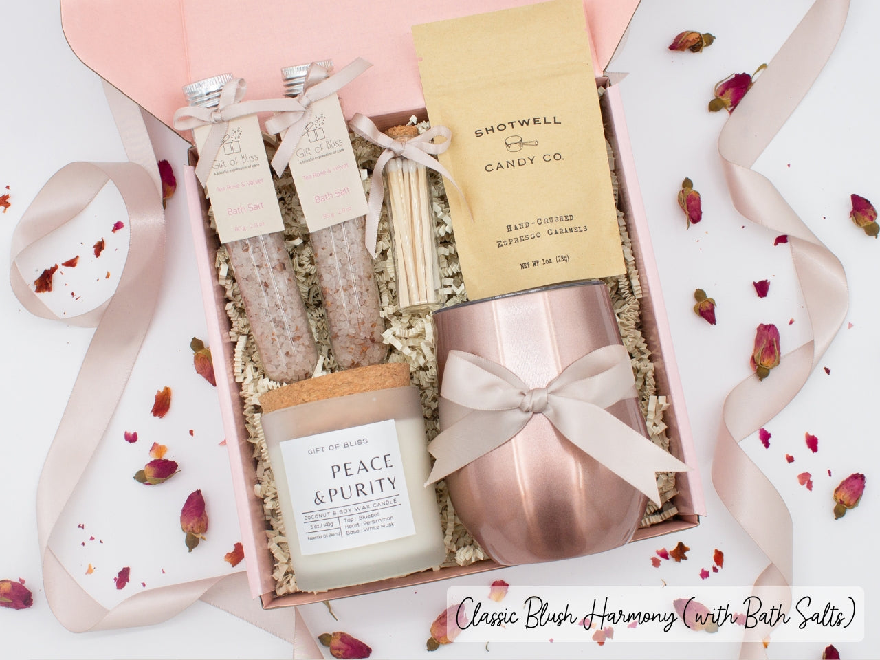 Luxury gift box for her. Featuring a stainless steel tumbler, an aromatherapy candle with matches, therapeutic bath salts, and gourmet caramel treats. All items are beautifully arranged for a pampering experience.a