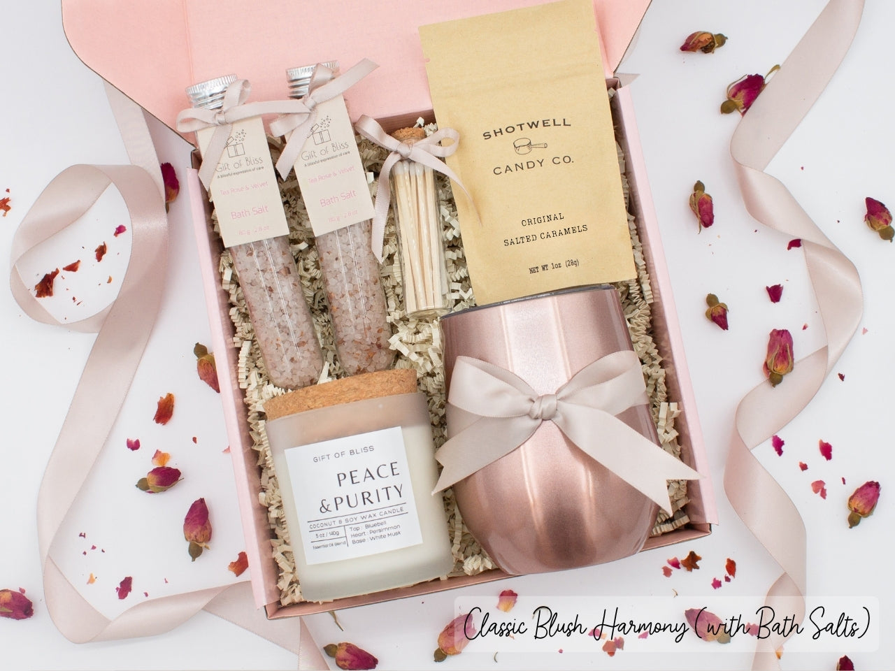 Luxury gift box for her. Featuring a stainless steel tumbler, an aromatherapy candle with matches, therapeutic bath salts, and gourmet caramel treats. All items are beautifully arranged for a pampering experience.a