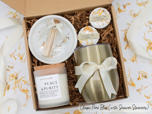 Luxury gift box for her. Featuring a stainless steel tumbler, an aromatherapy candle with matches, aromatic shower steamers, and a sleek ceramic dish. All items are beautifully arranged for a pampering experience.