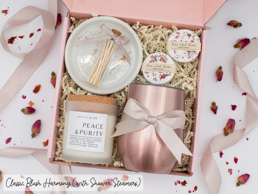 Luxury gift box for her. Featuring a stainless steel tumbler, an aromatherapy candle with matches, aromatic shower steamers, and a sleek ceramic dish. All items are beautifully arranged for a pampering experience.