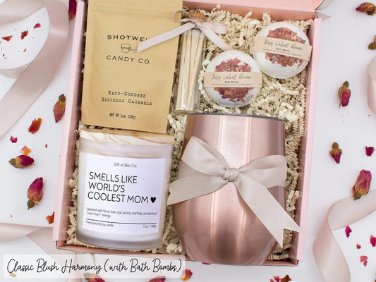 Luxury gift box for mom. Featuring a stainless steel tumbler, an aromatherapy candle with mom-themed label and charming match jar, luxury bath bombs, and gourmet caramel treats. All items are beautifully arranged for a pampering experience.