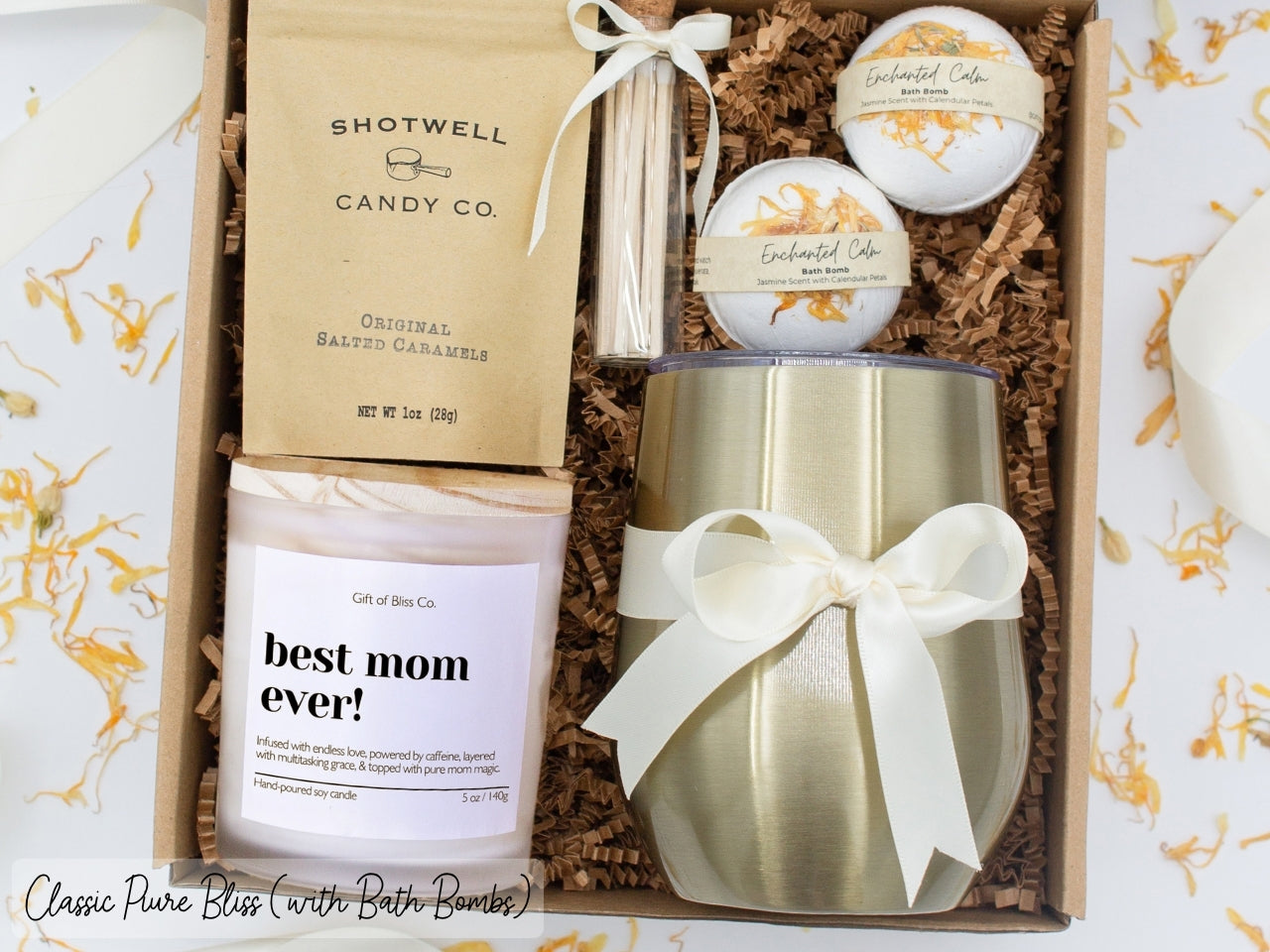 Luxury gift box for mom. Featuring a stainless steel tumbler, an aromatherapy candle with with mom-themed label and charming match jar, luxury bath bombs, and gourmet caramel treats. All items are beautifully arranged for a pampering experience.