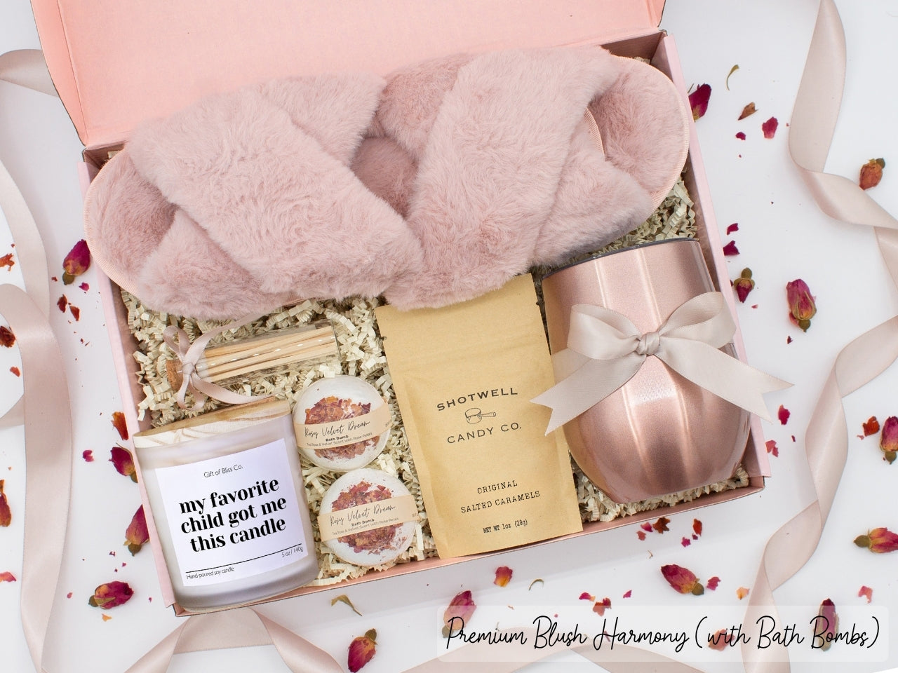 Luxury gift box for mom. Featuring a stainless steel tumbler, an aromatherapy candle with with mom-themed label and charming match jar, luxury bath bombs, plush open-toe slippers, and gourmet caramel treats. All items are beautifully arranged for a pampering experience.