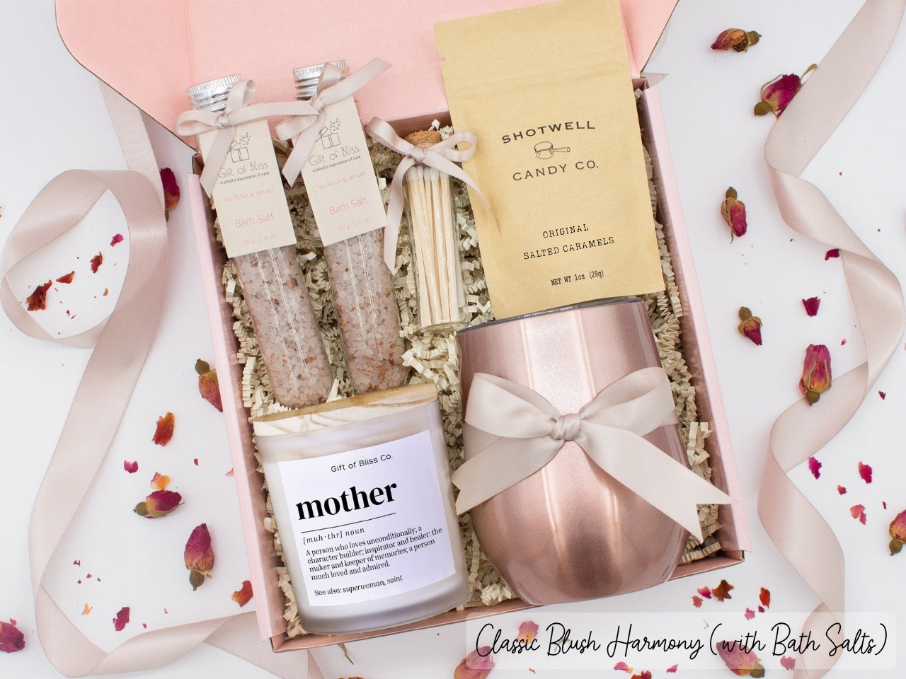 Luxury gift box for mom. Featuring a stainless steel tumbler, an aromatherapy candle with mom-themed label and charming match jar, therapeutic bath salts, and gourmet caramel treats. All items are beautifully arranged for a pampering experience.