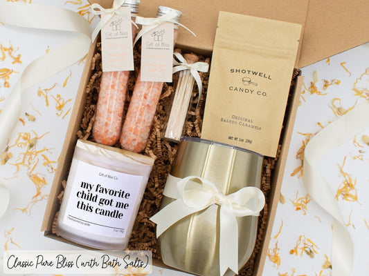 Luxury gift box for her. Featuring a stainless steel tumbler, an aromatherapy candle with mom-themed label and a charming match jar, therapeutic bath salts, and gourmet caramel treats. All items are beautifully arranged for a pampering experience.