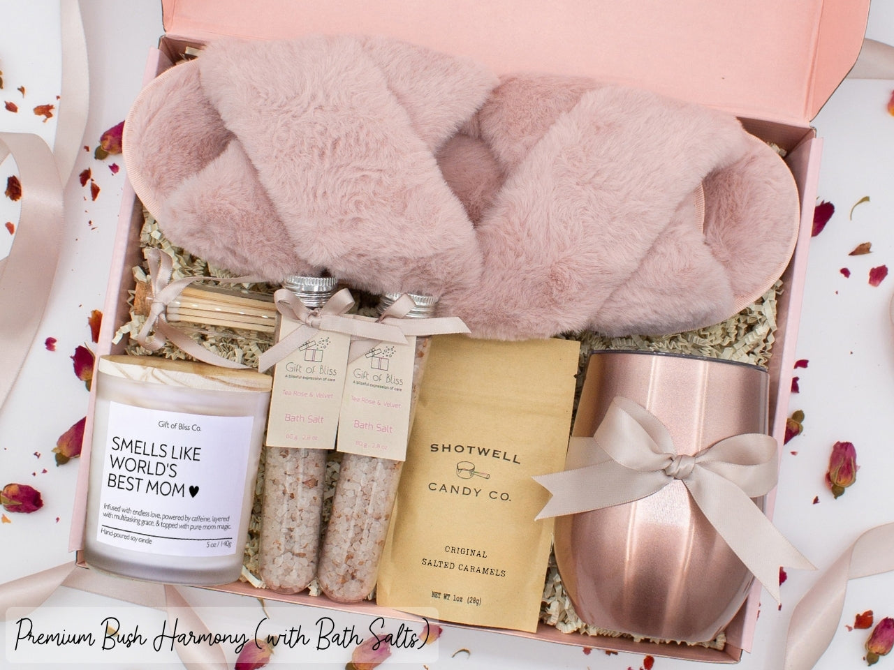 Luxury gift box for mom. Featuring a stainless steel tumbler, an aromatherapy candle with mom-themed label and charming match jar, therapeutic bath salts, plush open-toe slippers, and gourmet caramel treats. All items are beautifully arranged for a pampering experience.