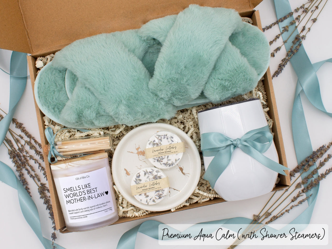 Luxury gift box for her. Featuring a stainless steel tumbler, an aromatherapy candle with mom-themed label and charming match jar, aromatic shower steamers, sleek ceramic dish, and plush open-toe slippers. All items are beautifully arranged for a pampering experience.