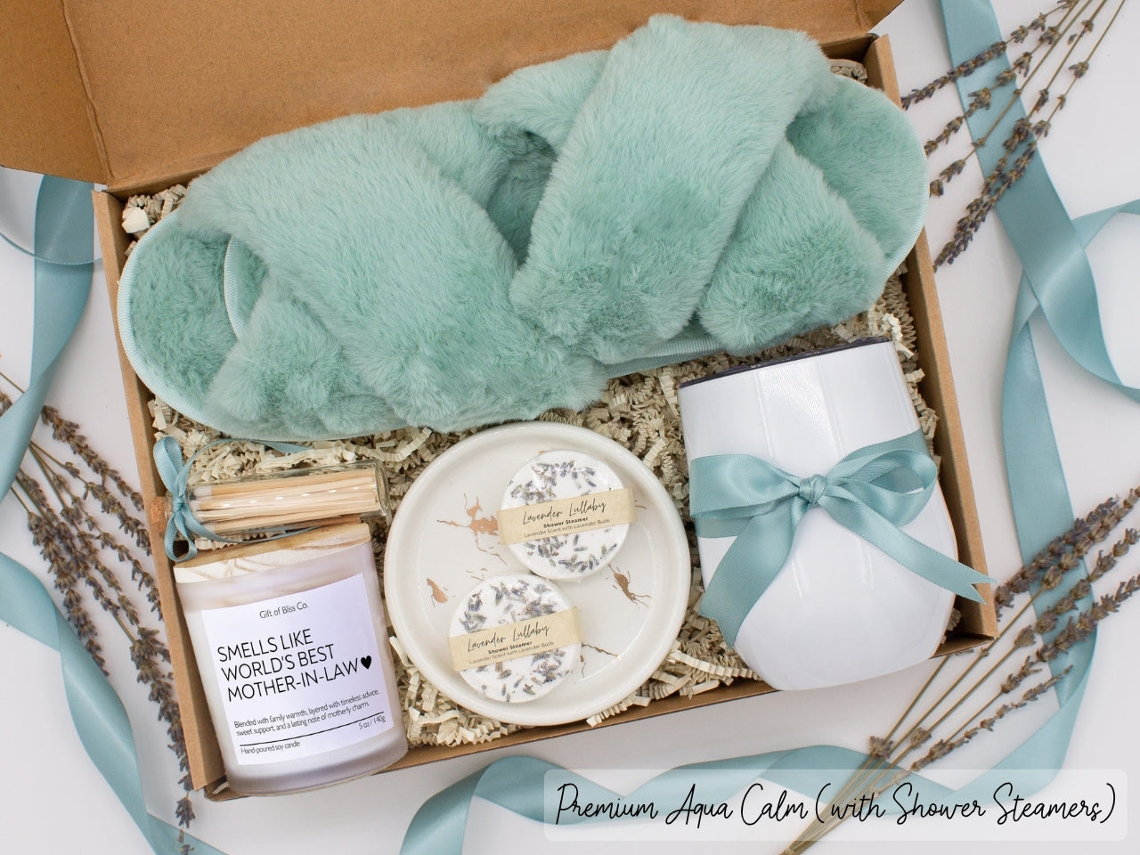 Luxury gift box for mom. Featuring a stainless steel tumbler, an aromatherapy candle with mom-themed label and charming match jar, aromatic shower steamers, sleek ceramic dish, and plush open-toe slippers. All items are beautifully arranged for a pampering experience.