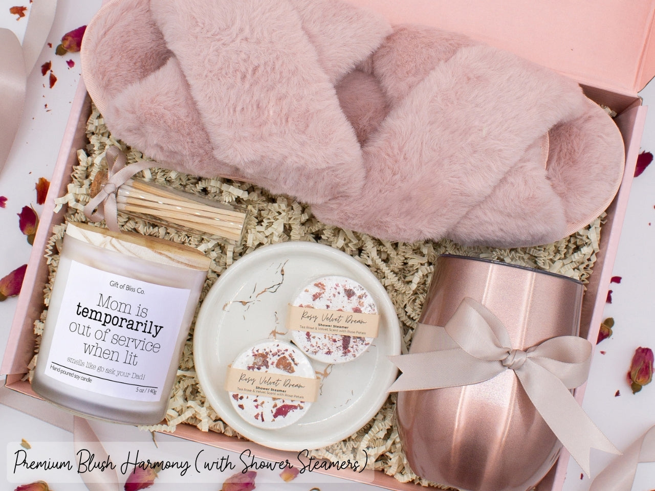 Luxury gift box for mom. Featuring a stainless steel tumbler, an aromatherapy candle with mom-themed label and charming match jar, aromatic shower steamers, sleek ceramic dish, and plush open-toe slippers. All items are beautifully arranged for a pampering experience.
