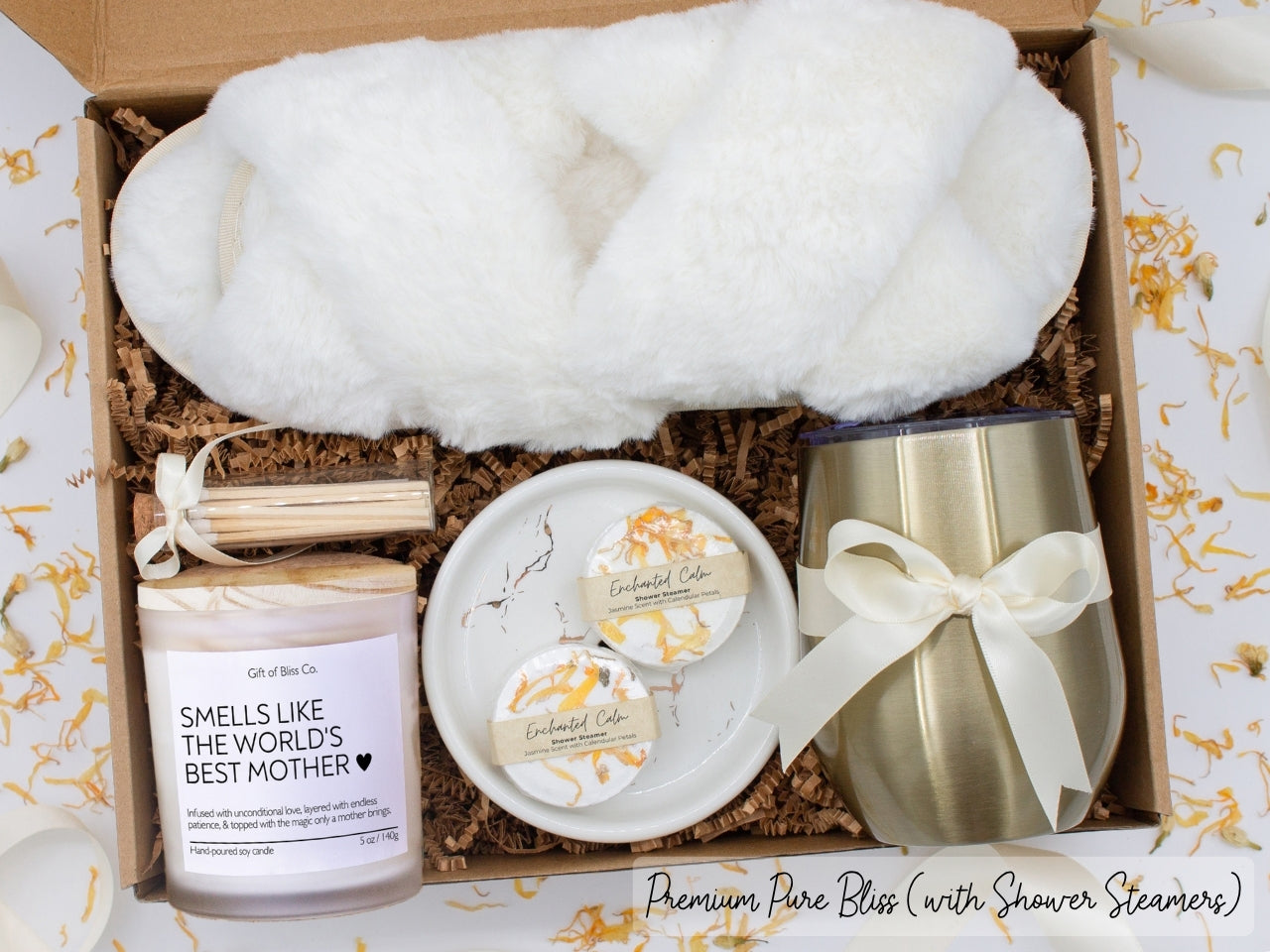 Luxury gift box for mom. Featuring a stainless steel tumbler, an aromatherapy candle with mom-themed label and charming match jar, aromatic shower steamers, sleek ceramic dish, and plush open-toe slippers. All items are beautifully arranged for a pampering experience.