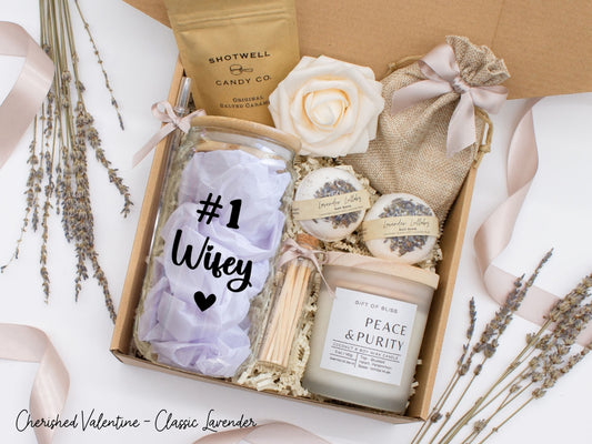 Pesonalized Valentine's Day spa gift basket for her with fragrant bath treats, personalized glass tumbler, soft caramels, relaxing candle, and a beautifull rose. Pick from one of the three scents: Rose, Lavender, or Jasmine. Perfect to pamper and honor her.