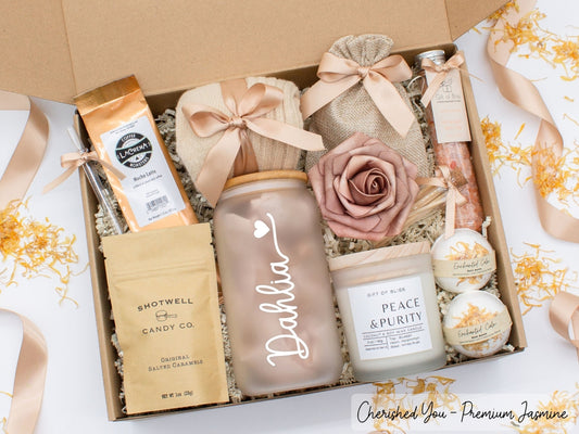 Personalized spa gift set for her with bath treats, personalized glass tumbler, mocha latte coffe, caramels, relaxing candle, cozy socks, and a lovely rose. Pick from 1 of the three scents: Rose, Lavender, or Jasmine. Perfect to pamper and honor her.