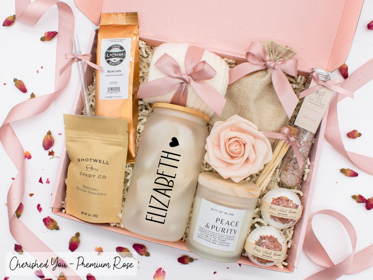 Personalized spa gift set for her with bath treats, personalized glass tumbler, mocha latte coffe, caramels, relaxing candle, cozy socks, and a lovely rose. Pick from 1 of the three scents: Rose, Lavender, or Jasmine. Perfect to pamper and honor her.