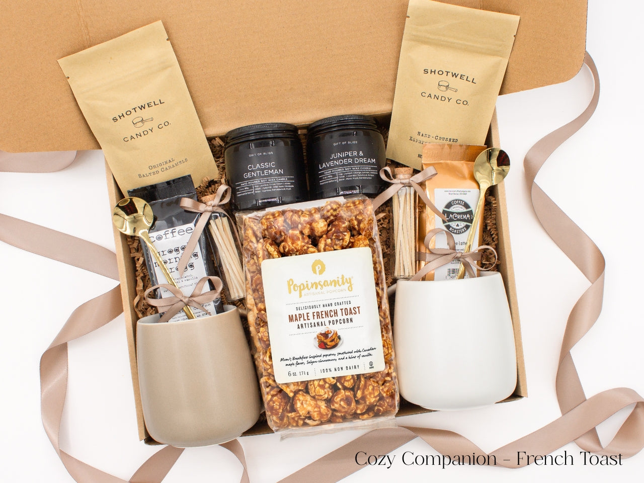 A gift box for two. Includes two ceramic mugs with golden spoons, a selection of fine coffees, two safety match jars, his and hers aromatherapy candles, caramel candies, and artisan popcorn, all for shared moments of joy.