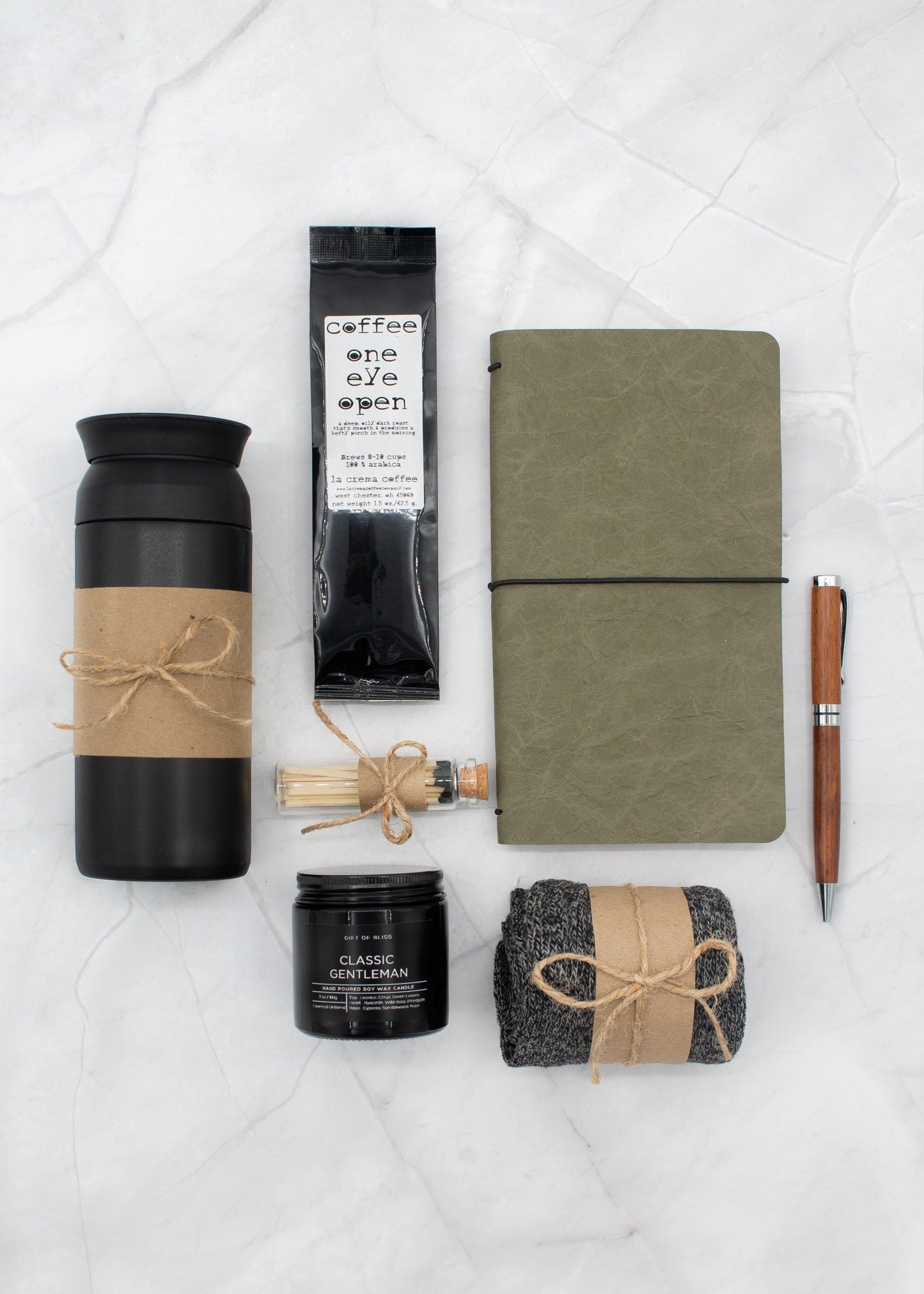 Specially crafted gift box for men, suitable for anyone valuing timeless style. Includes a stainless steel tumbler, coffee, aromatherapy candle, men's socks, notebook, and a wooden pen. A perfect gift for a comforting & indulgent experience.