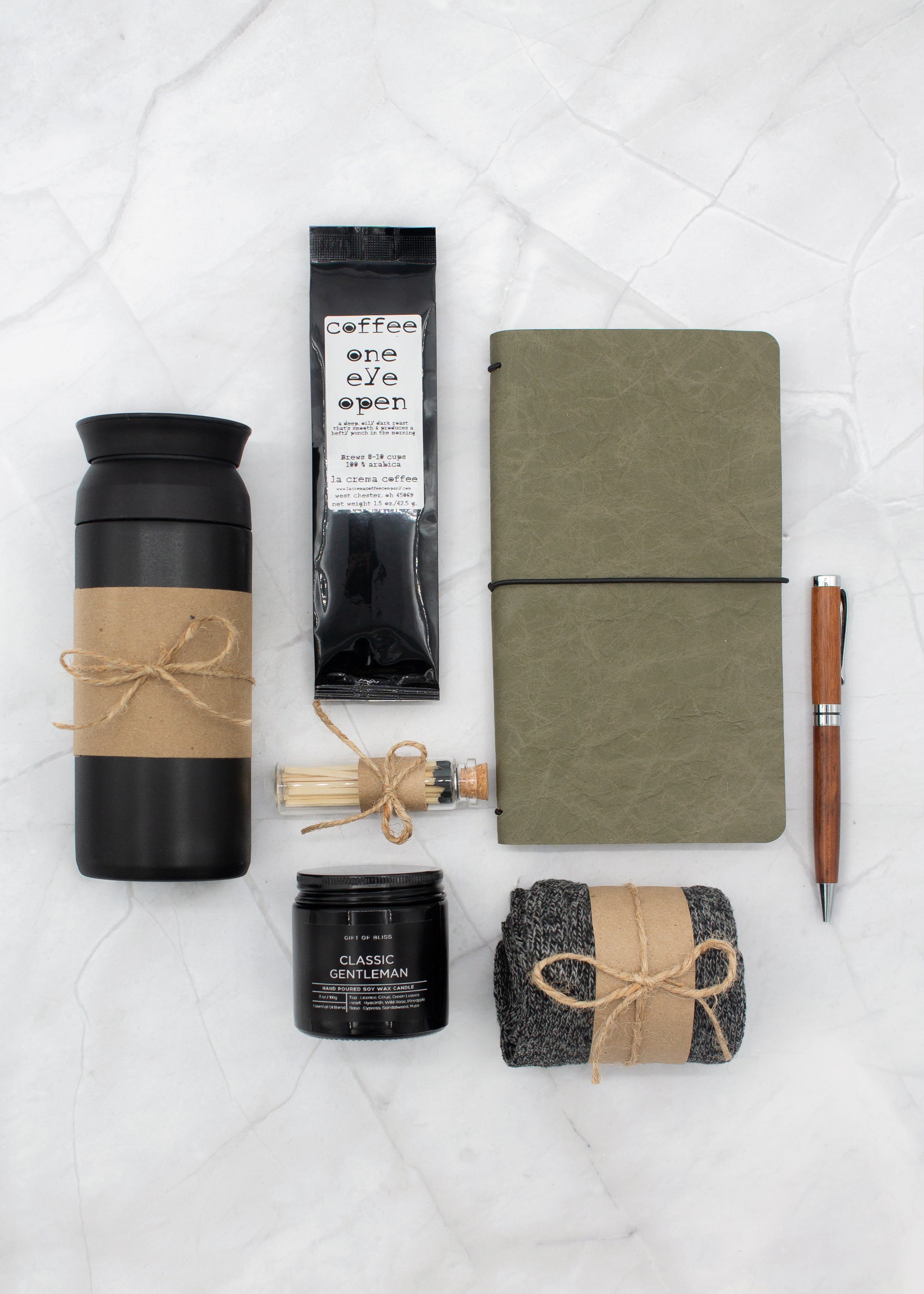Specially crafted gift box for men, suitable for anyone valuing timeless style. Includes a stainless steel tumbler, coffee, aromatherapy candle, men's socks, notebook, and a wooden pen. A perfect gift for a comforting & indulgent experience.