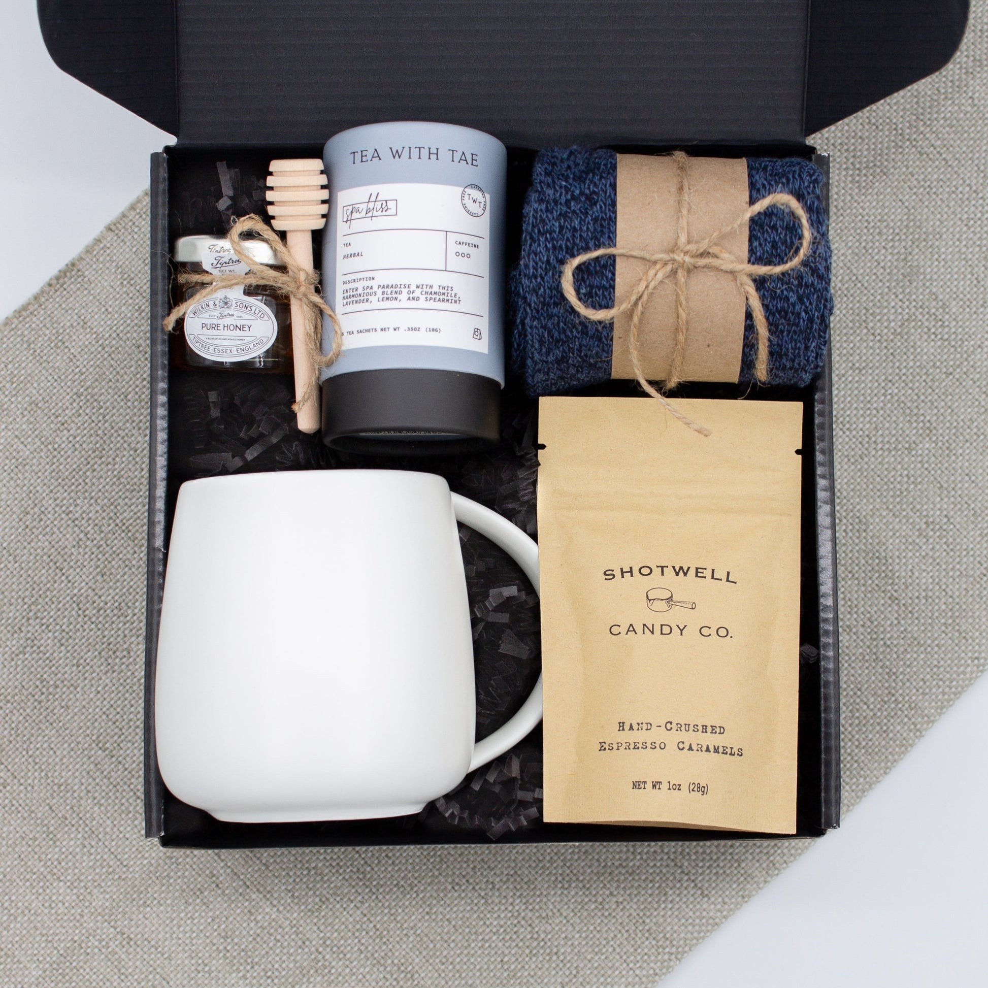 The Dapper Haven Basic (Specially crafted gift box for men. Includes a minimalist ceramic mug, tea, pure honey with wooden dipper, caramel candy, and cozy men's socks. A gift that brings joy and a touch of tranquility to anyone who loves life's finer things.)