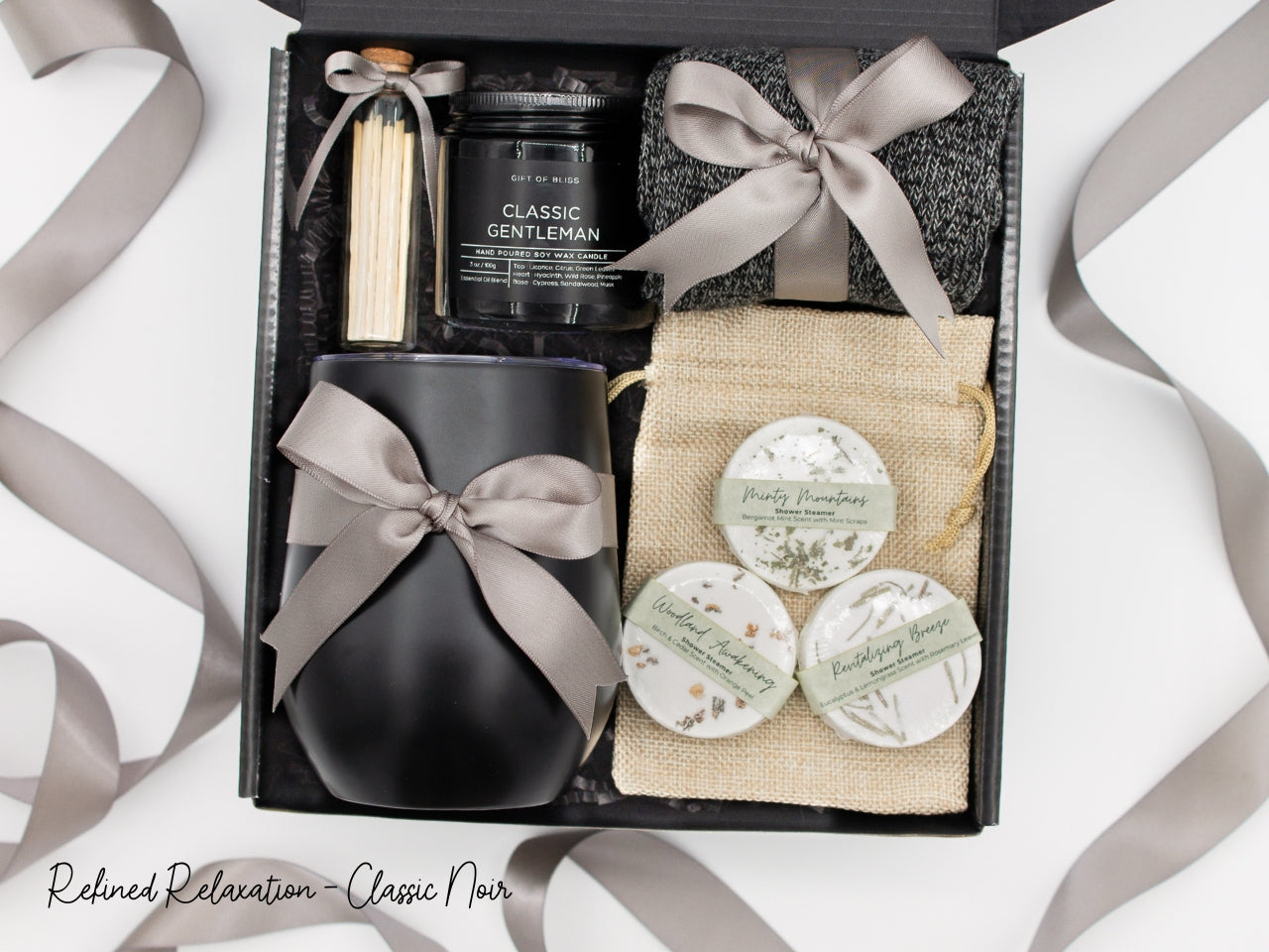 Specially crafted gift box that brings luxury and relaxation. Includes a 12oz stainless steel tumbler, sweet treats, an aromatic candle and matches, cozy socks, and a selection of shower steamer for a serene experience.