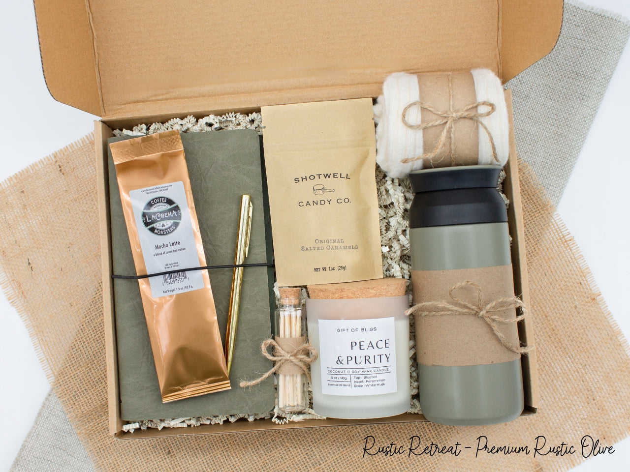 A specially crafted gift box for those who appreciate rustic charm and elegance. Features 12 oz tumbler, coffee, luxurious caramel, notebook with gold pen, soothing candle with matches, and cozy socks, perfect for both relaxation and practicality.