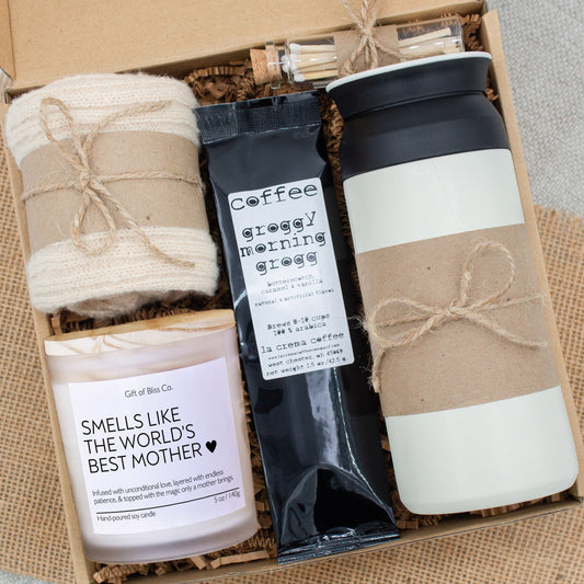 Rustic Retreat gift box in Basic Rustic Neutral theme, featuring a white 12oz stainless steel tumbler, “Smells like the world best mother" candle, safety match jar, mocha latte coffee, salted caramels, and cozy socks. All items are arranged in kraft paper with jute cord for a charming, earthy presentation. A thoughtful, cozy gift set ideal for Mother’s Day or self-care.
