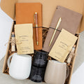 A gift box for two, features two ceramic mugs, two notebooks with a gold pen and a wooden pen, gourmet caramel candies, and two aromatic candles. Perfect for couples, friends, or colleagues to enjoy a relaxing, creative experience together.