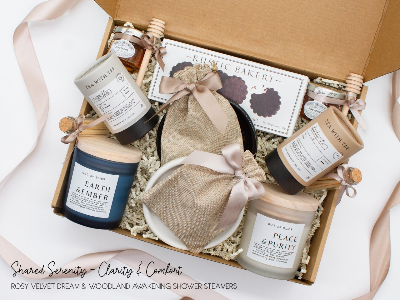 A spa gift box for two. Features shortbread cookies, 2 soothing tea blends, honey and wooden dipper, 2 aromatic candles, 2 sets of shower steamers, and 2 sleek ceramic dishes. This elegantly curated box, ideal for couples, enhances shared moments of intimacy and relaxation.