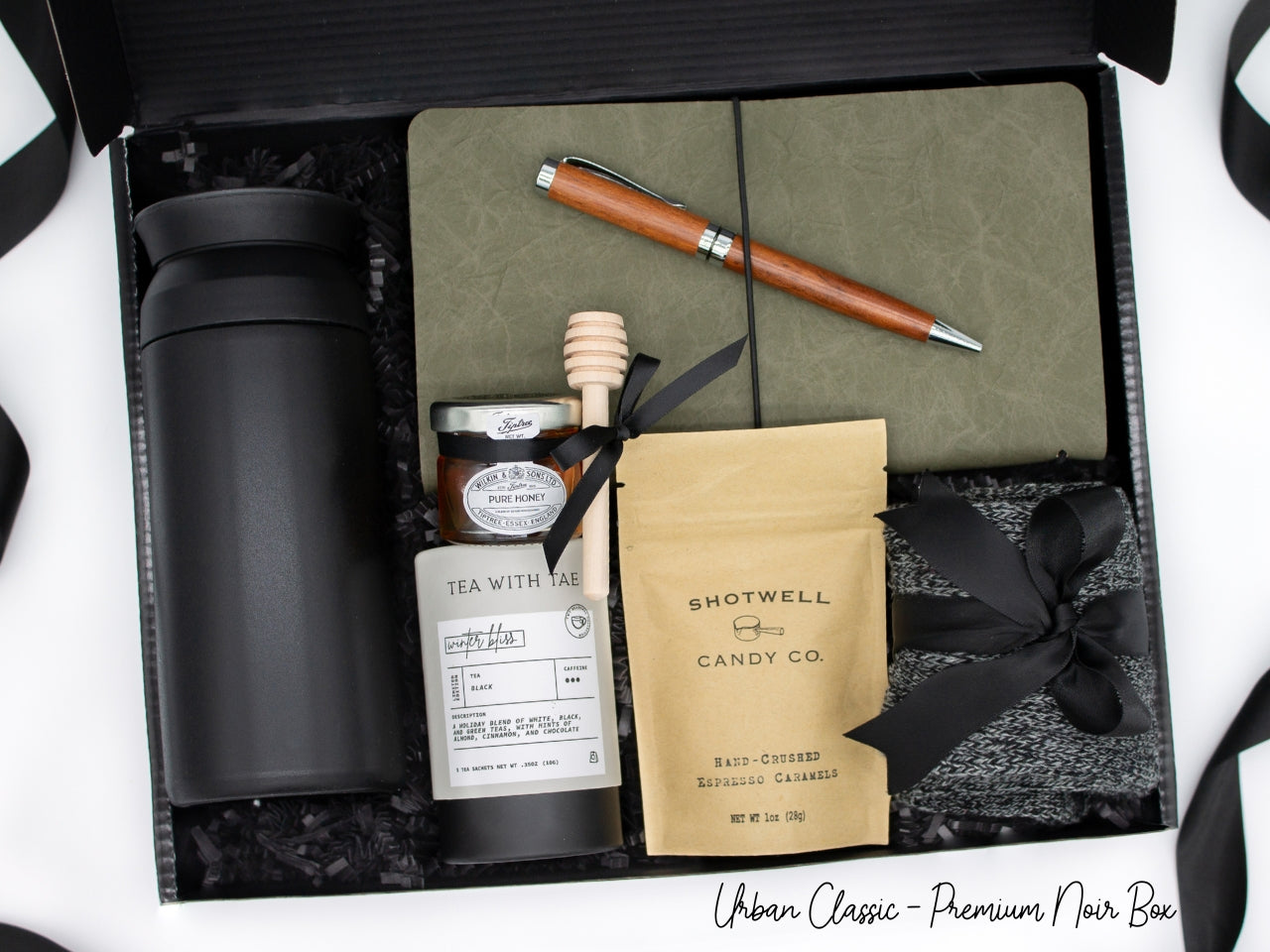 Specially crafted gift box for men, ideal for anyone. Includes a stainless steel tumbler, tea, honey, sweet treats, cozy socks, vegan leather notebook, & wooden pen. Perfect for relaxation & appreciation, complete with a personalized greeting card.