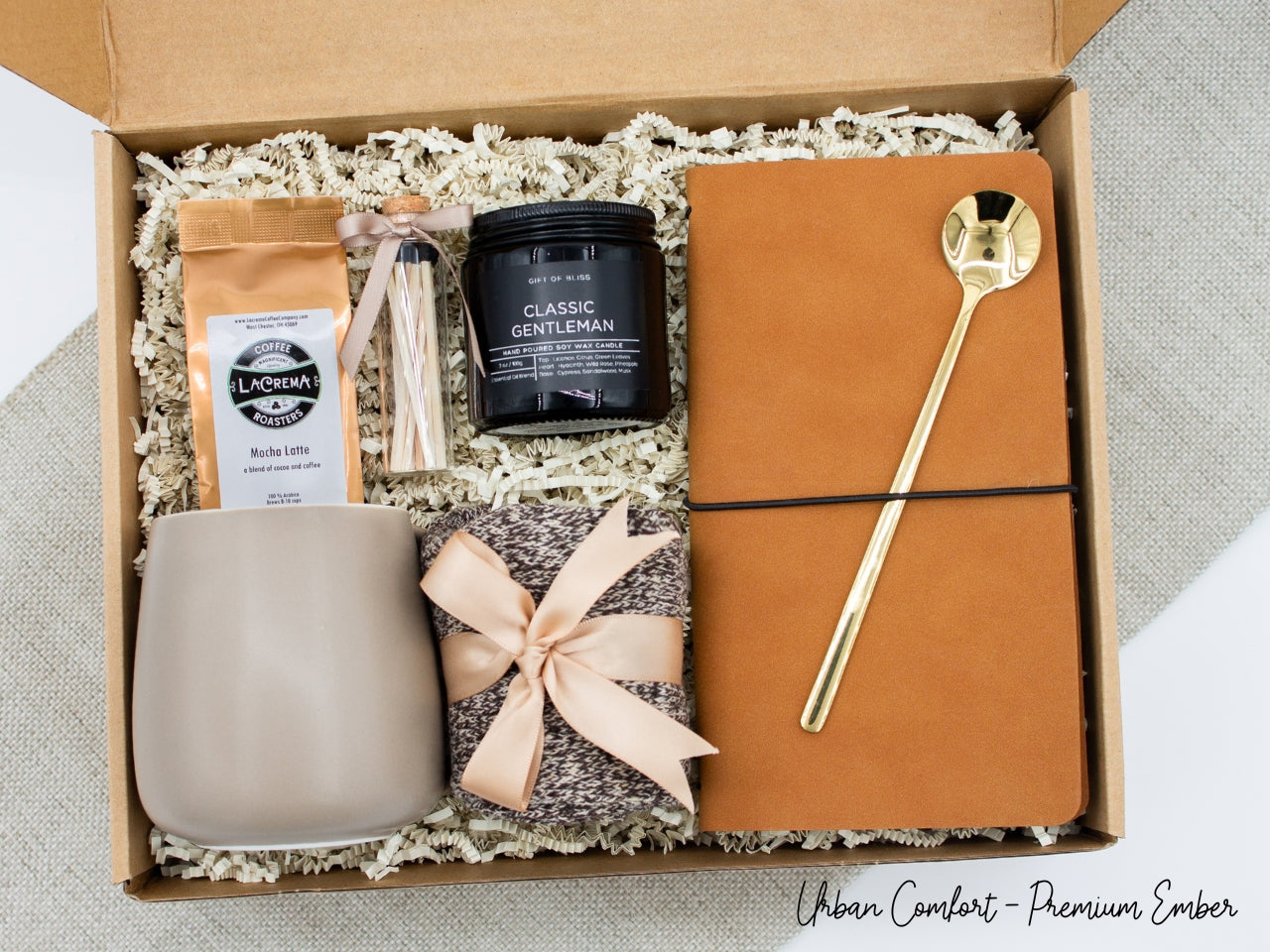 Specially crafted gift box, ideal for modern individuals who value style and comfort. Includes 12 oz ceramic mug, long-handled golden spoon, rich coffee, aromatic candles and matches, stylish men's socks, and notebook, all arranged for a memorable experience.