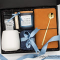 Specially crafted gift box, ideal for modern individuals who value style and comfort. Includes 12 oz ceramic mug, long-handled golden spoon, rich coffee, aromatic candles and matches, stylish men's socks, and notebook, all arranged for a memorable experience.